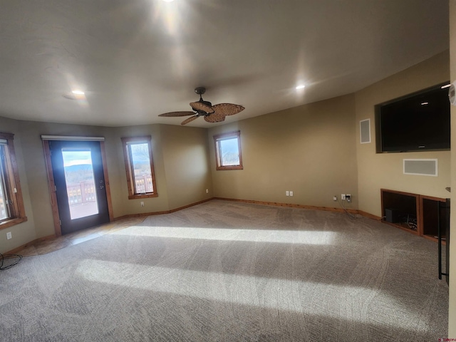 empty room featuring ceiling fan and light carpet