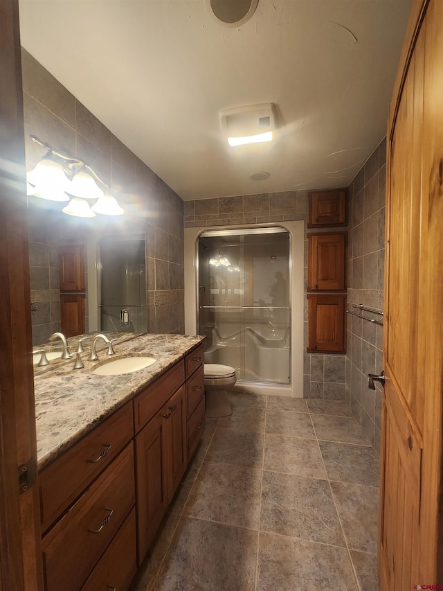 bathroom featuring tile walls, toilet, vanity, and an enclosed shower