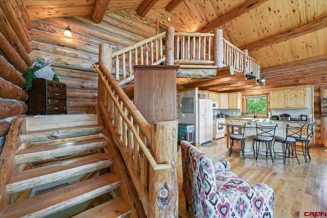 staircase featuring beamed ceiling, high vaulted ceiling, wood-type flooring, wooden ceiling, and log walls