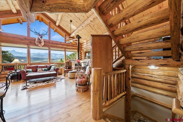 living room with a mountain view, beamed ceiling, wood ceiling, high vaulted ceiling, and hardwood / wood-style flooring