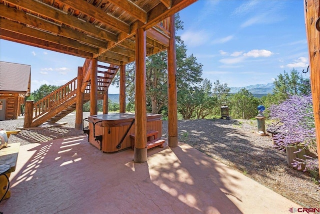 view of patio with a mountain view and a hot tub