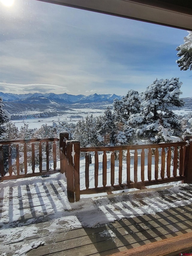 snow covered deck with a mountain view