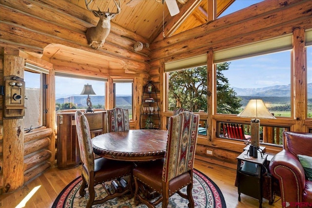 dining room featuring a mountain view, vaulted ceiling, and a healthy amount of sunlight