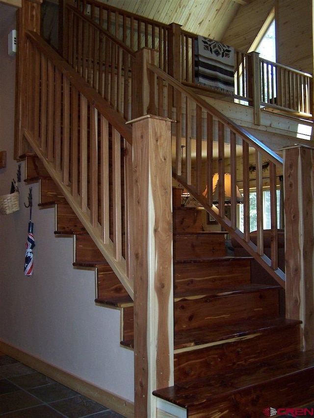 staircase with lofted ceiling, plenty of natural light, and baseboards