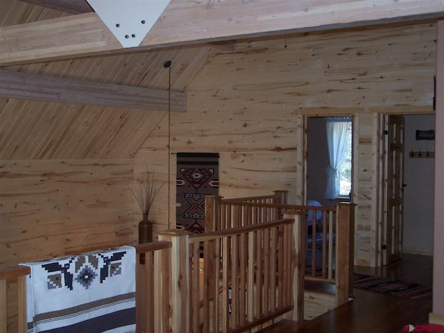 interior space with wooden ceiling, vaulted ceiling with beams, and wood walls