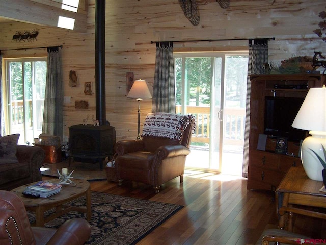 living room featuring wood walls, a healthy amount of sunlight, and wood-type flooring