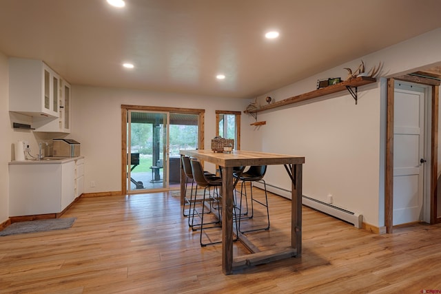 dining room with recessed lighting, light wood-style flooring, baseboards, and baseboard heating