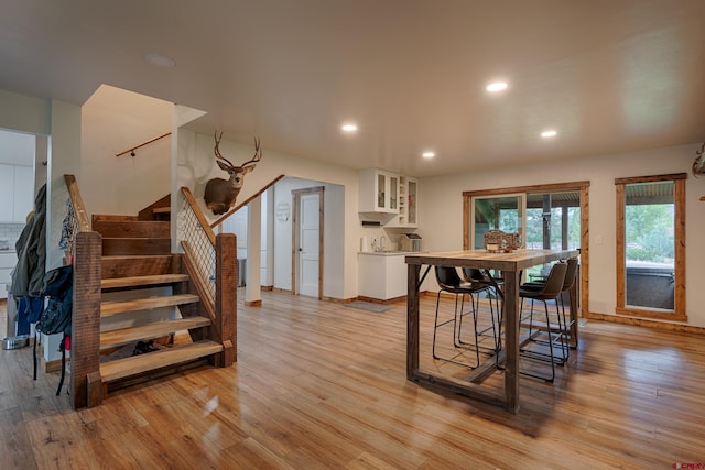 dining space featuring recessed lighting, light wood-style flooring, baseboards, and stairs