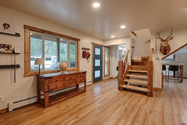 foyer entrance with a baseboard radiator, recessed lighting, light wood-style floors, and stairway