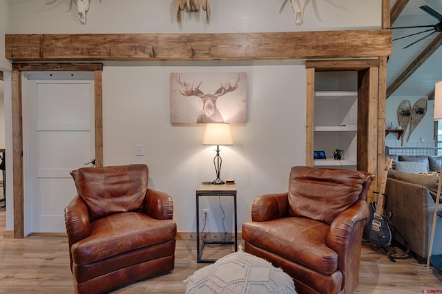 living area with a ceiling fan and wood finished floors