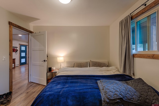 bedroom featuring baseboard heating and light wood-style floors