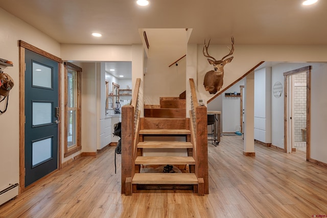 stairs featuring a baseboard heating unit, baseboards, wood finished floors, and recessed lighting