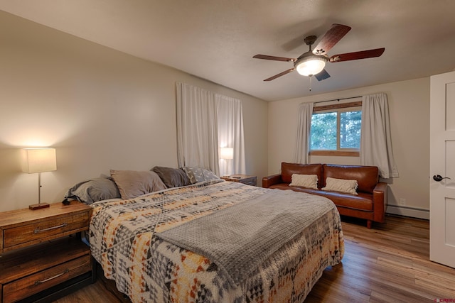 bedroom featuring a baseboard radiator, a ceiling fan, and wood finished floors