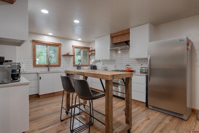 kitchen featuring light countertops, light wood-style floors, appliances with stainless steel finishes, and a sink
