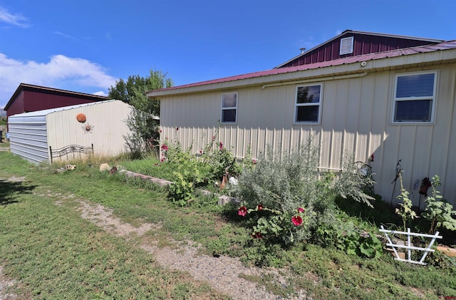 view of home's exterior with a storage shed and a yard