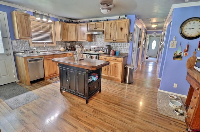 kitchen with a kitchen island, stainless steel appliances, light hardwood / wood-style floors, and ornamental molding