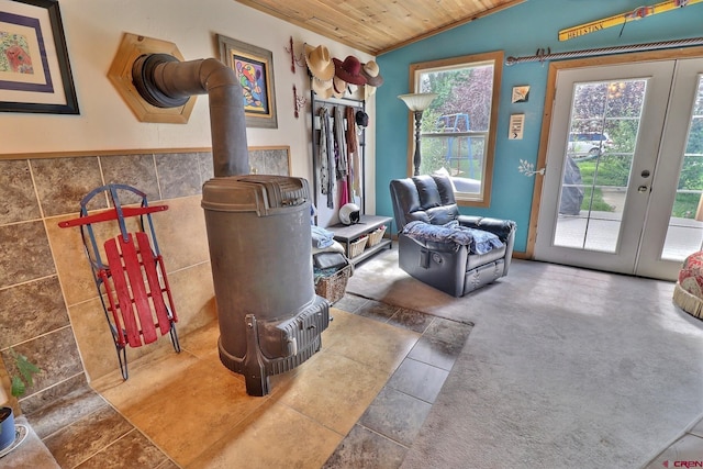 living area featuring wood ceiling, tile walls, vaulted ceiling, and a wood stove