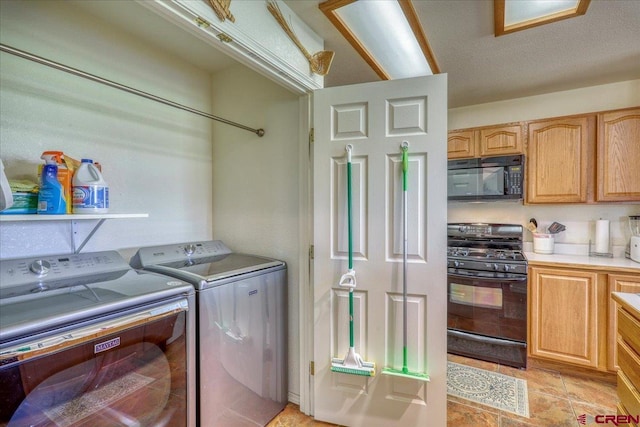 washroom with a textured ceiling and washer and clothes dryer