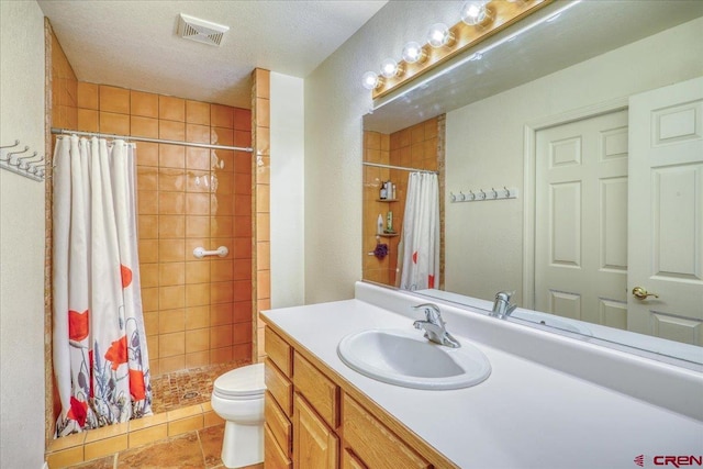 bathroom with a textured ceiling, a shower with shower curtain, vanity, tile patterned flooring, and toilet