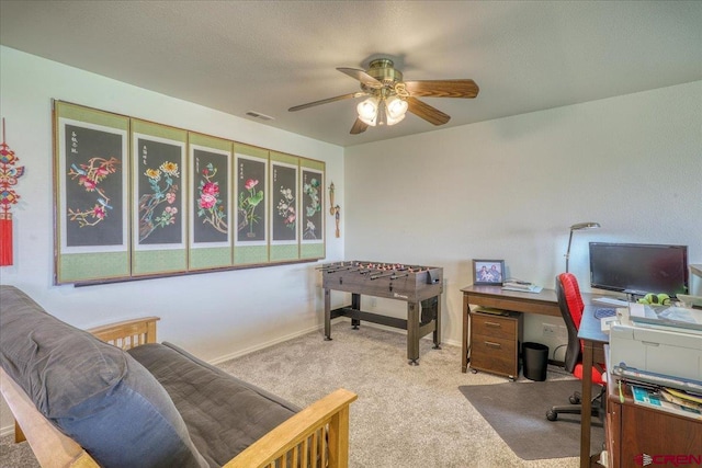 office space featuring carpet flooring, ceiling fan, and a textured ceiling