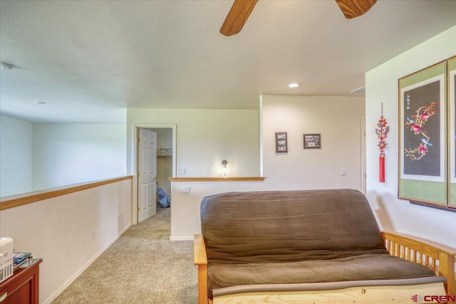 sitting room with light colored carpet, a textured ceiling, and ceiling fan