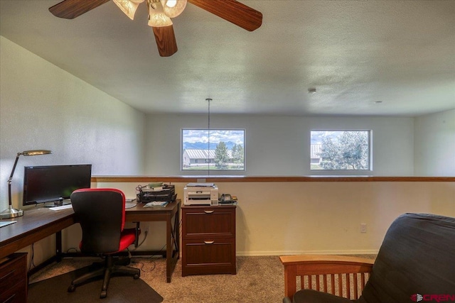 carpeted office space with a textured ceiling and ceiling fan