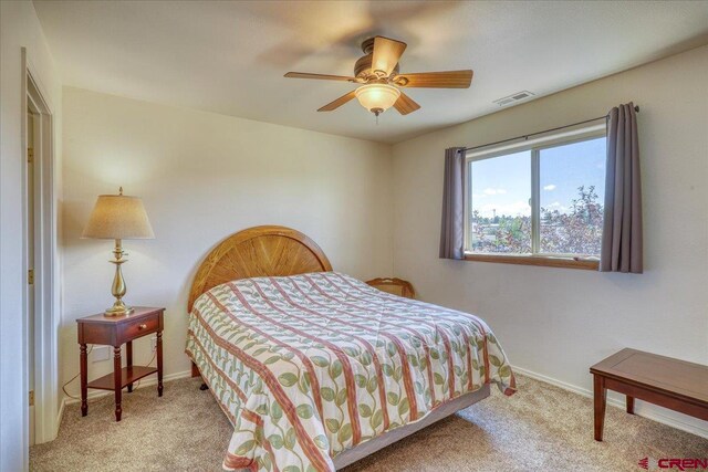 bedroom with ceiling fan and light carpet