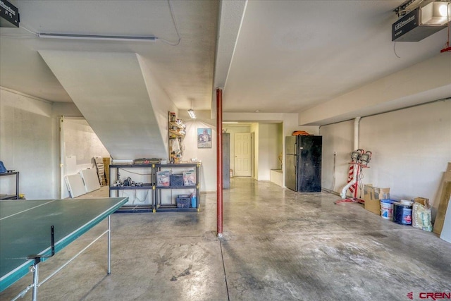 garage with black fridge and a garage door opener