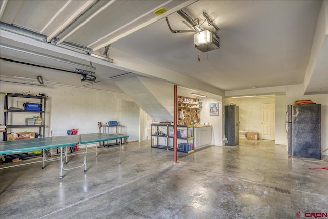 garage with black fridge and a garage door opener