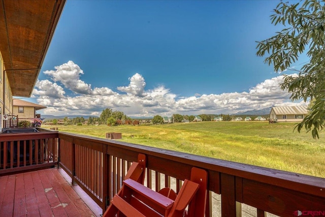 deck featuring a lawn and a rural view