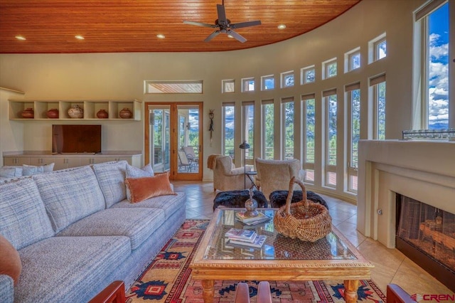 living room with ceiling fan, plenty of natural light, light tile patterned flooring, and wooden ceiling