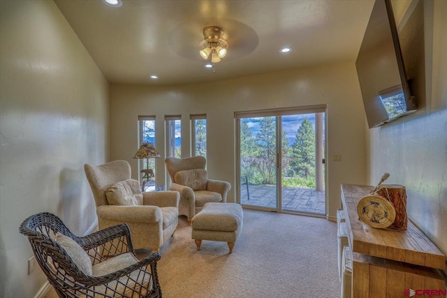 living area with ceiling fan and carpet floors