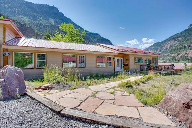 rear view of property featuring a patio and a deck with mountain view