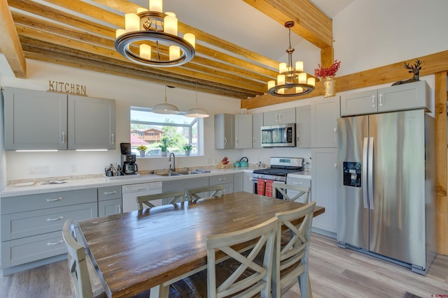 kitchen featuring stainless steel appliances, a chandelier, beamed ceiling, sink, and pendant lighting