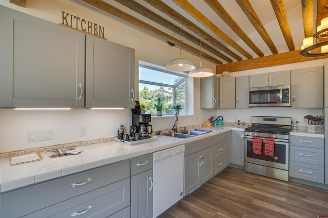 kitchen featuring decorative light fixtures, stainless steel appliances, dark hardwood / wood-style flooring, and sink