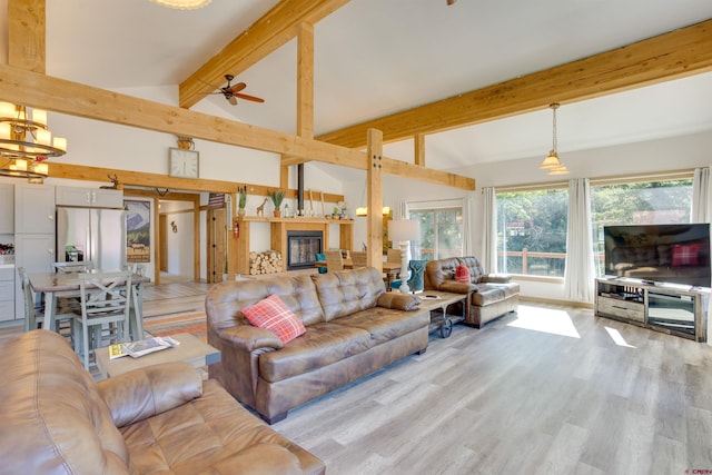 living room with ceiling fan with notable chandelier, high vaulted ceiling, light hardwood / wood-style flooring, and beam ceiling