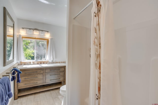 bathroom featuring toilet, hardwood / wood-style flooring, and vanity