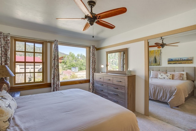 bedroom featuring multiple windows, ceiling fan, and carpet floors