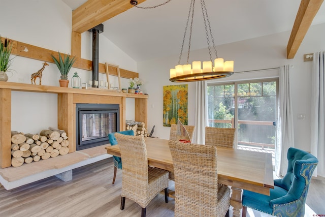 dining room featuring hardwood / wood-style flooring, a chandelier, and vaulted ceiling with beams