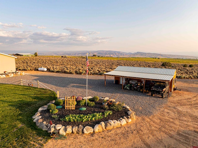 exterior space featuring a mountain view, a lawn, and a rural view