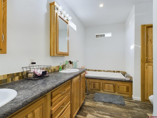 bathroom featuring vanity, toilet, hardwood / wood-style flooring, and a bathing tub