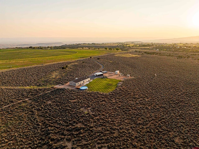 aerial view at dusk featuring a rural view