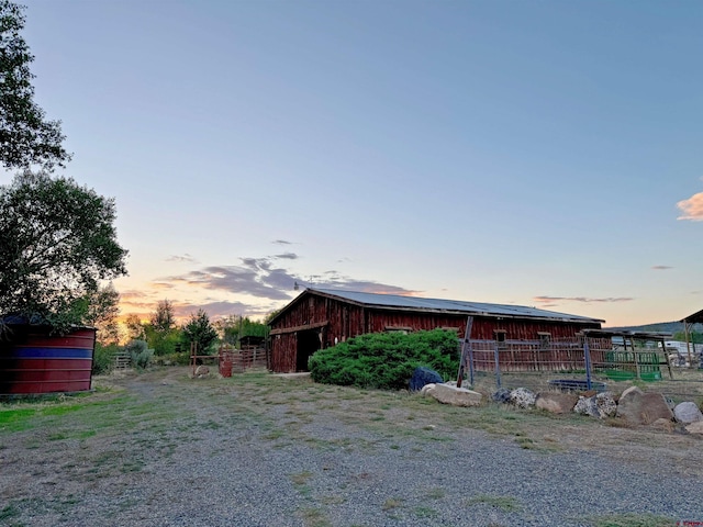 property exterior at dusk featuring an outbuilding