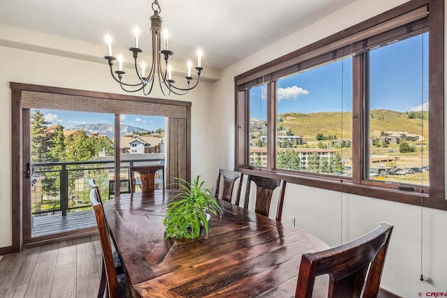 dining space featuring plenty of natural light, a mountain view, wood-type flooring, and a chandelier