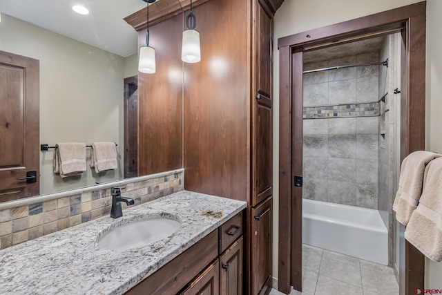 bathroom featuring tiled shower / bath, vanity, decorative backsplash, and tile patterned flooring