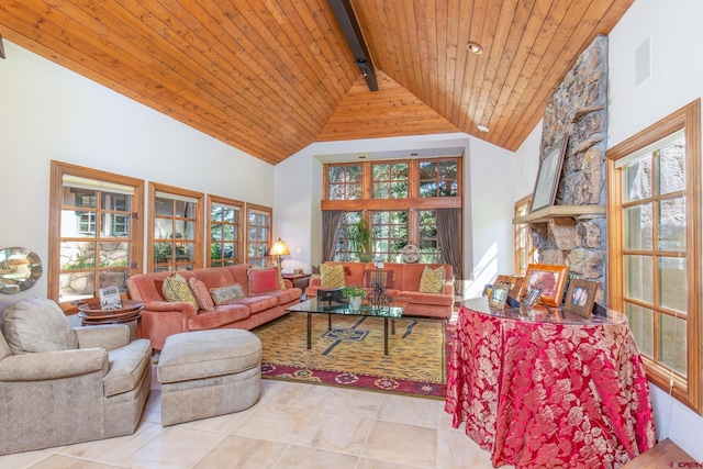 tiled living room featuring beamed ceiling, a stone fireplace, high vaulted ceiling, and wooden ceiling