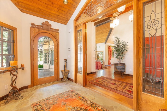 foyer entrance with vaulted ceiling with beams, wood-type flooring, and wooden ceiling