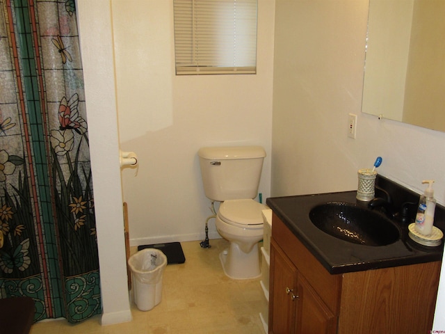 730 Washington St, Monte Vista, CO 81144 - full bathroom with baseboards, toilet, a shower with shower curtain, and vanity