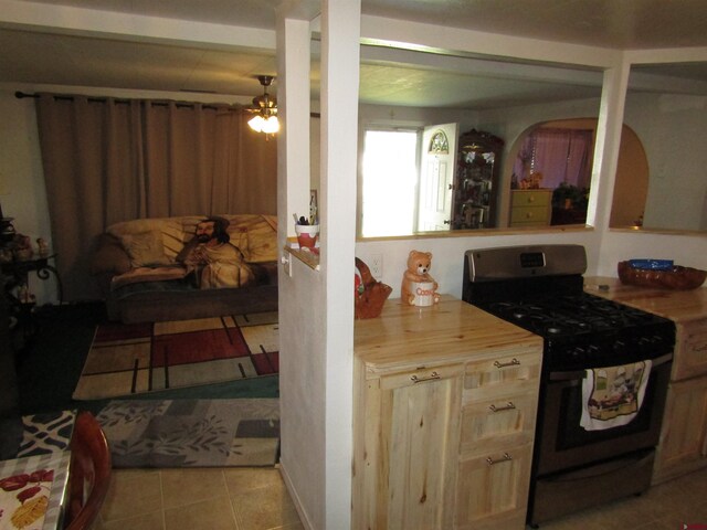 730 Washington St, Monte Vista, CO 81144 - kitchen featuring tile patterned floors, stainless steel range with gas stovetop, and a ceiling fan