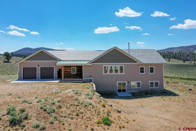 view of front of home featuring a mountain view, a rural view, and a garage